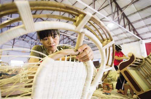 6月27日,陵水藤竹工艺品企业生产车间,工人正在编制特色黎族藤制